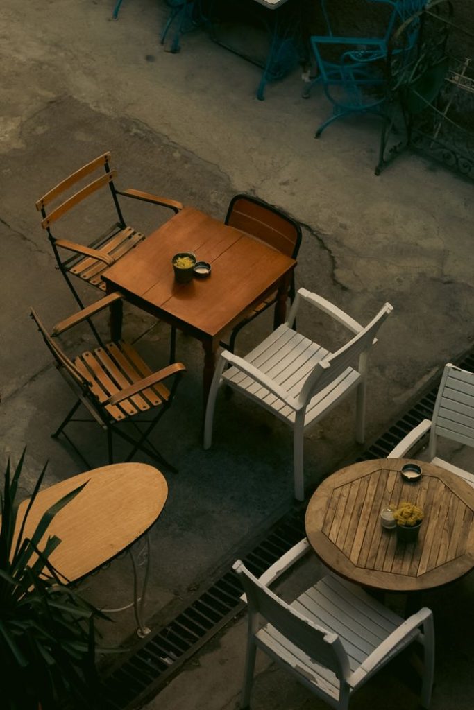 furniture-at-sidewalk-cafe-15336185 Aerial view of outdoor cafe tables with a cozy and inviting setup.