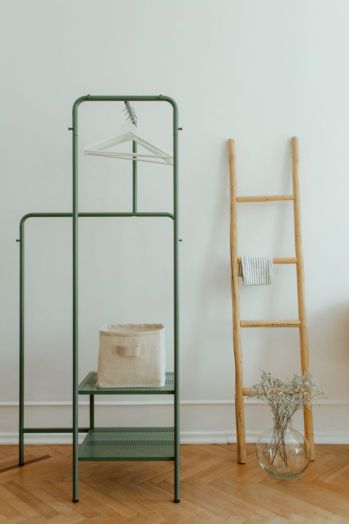 collection-04 A clean and simple home interior featuring a wooden ladder and a minimal clothing rack.
