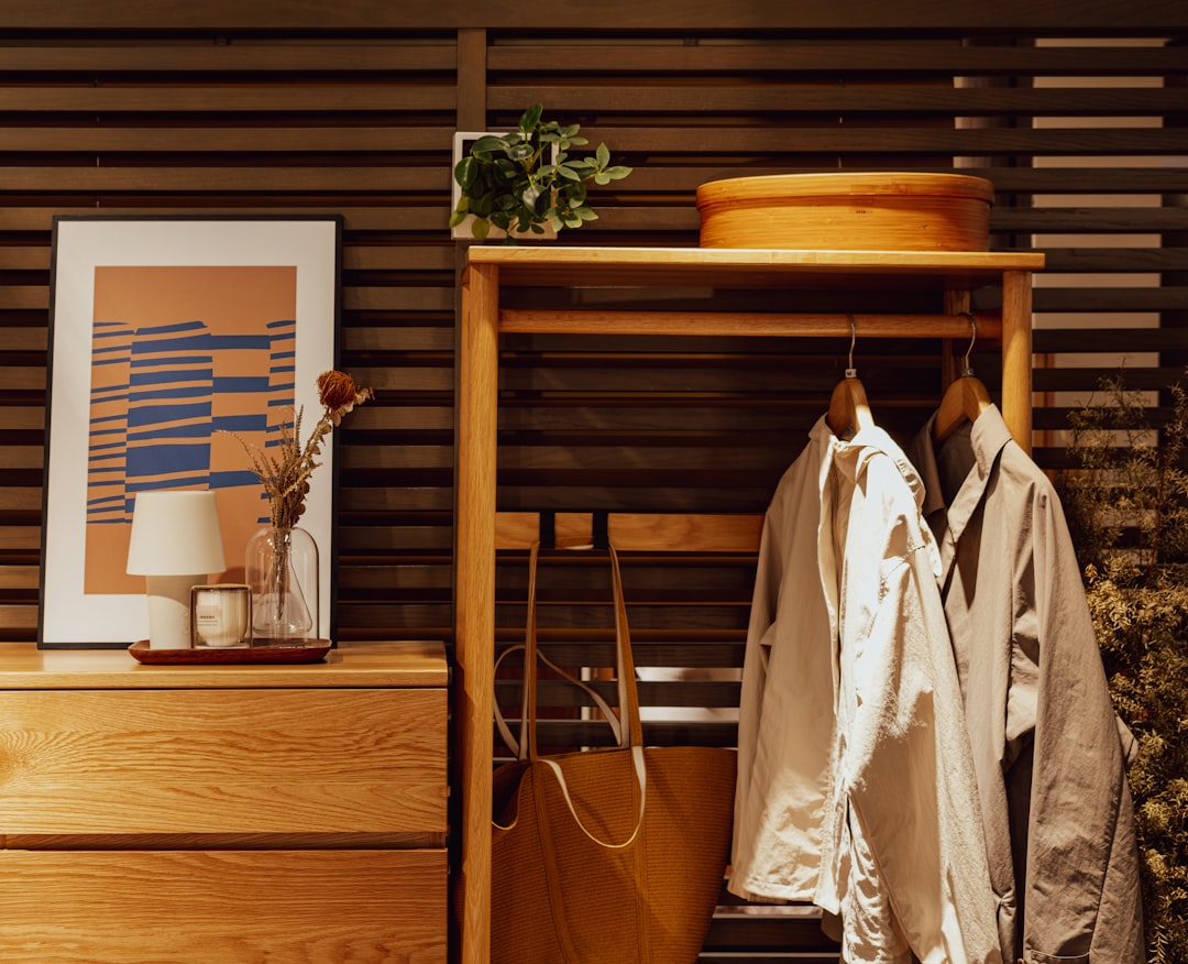 wooden-dresser-with-artwork-and-hanging-coats-bjktxo1wmpc